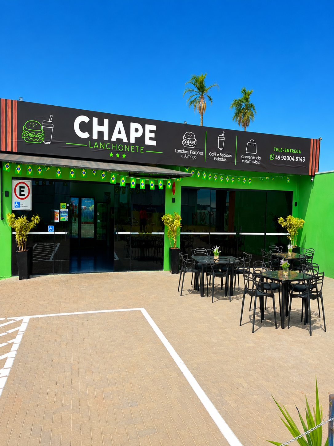 Fachada da Chape Lanchonete com mesas ao ar livre